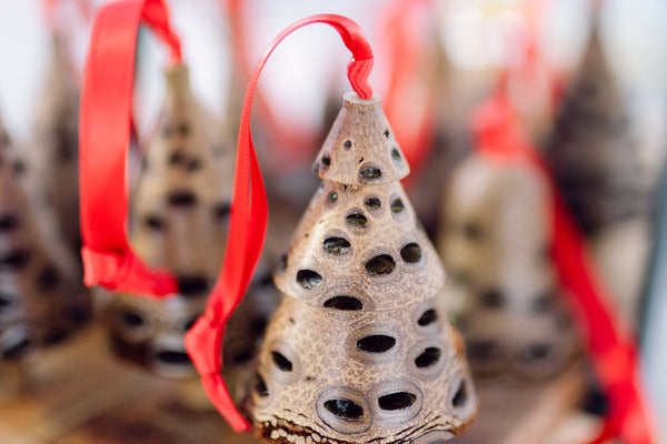 Tiered banksia pod Christmas decorations with red ribbons, handmade from Australian native seed pods