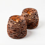 Two brown textured candle holders on a white background