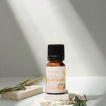 Bottle of Mandarin essential oil on a light background with shadows