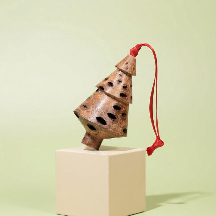 Tiered Banksia pod Christmas tree ornament with red ribbon on a green display pedestal