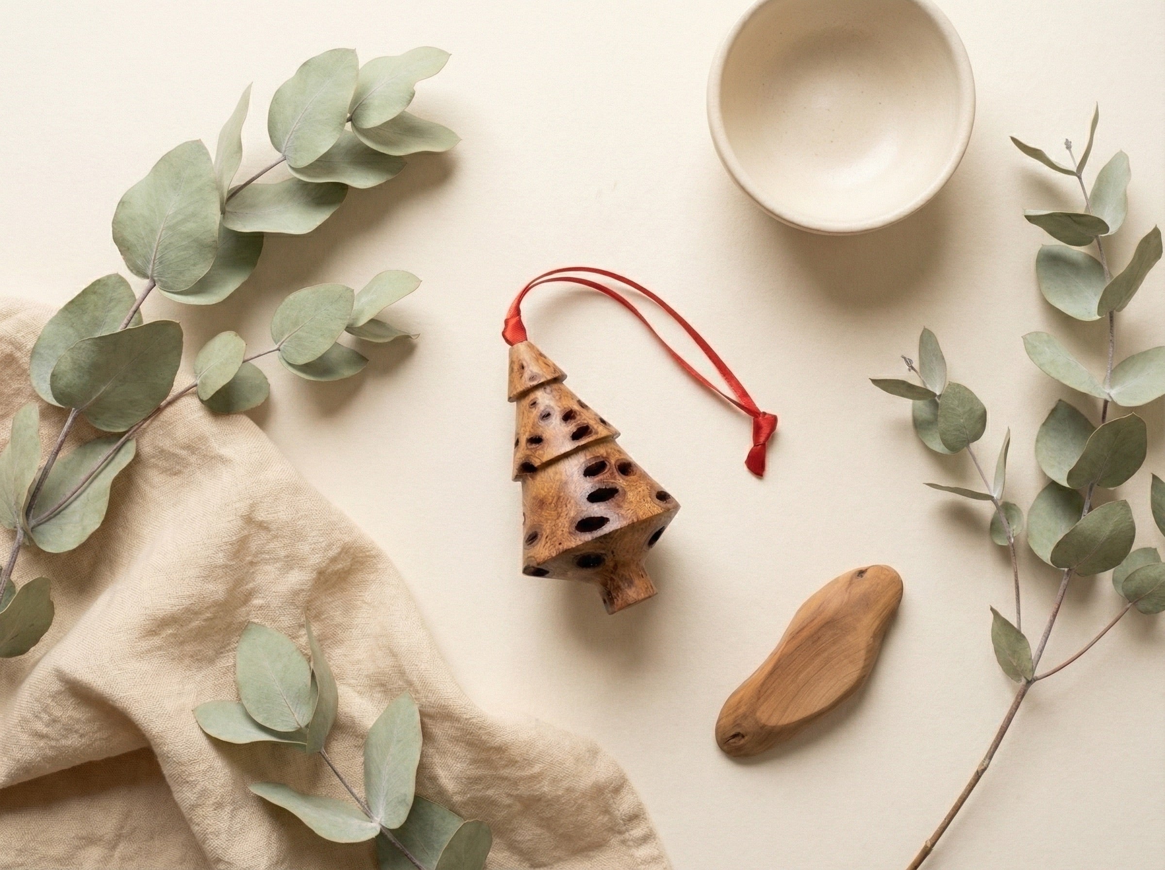 Banksia pod tiered Christmas tree decoration styled with eucalyptus leaves and linen