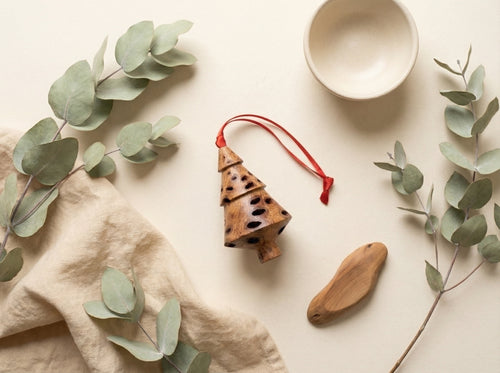 Banksia pod tiered Christmas tree decoration styled with eucalyptus leaves and linen