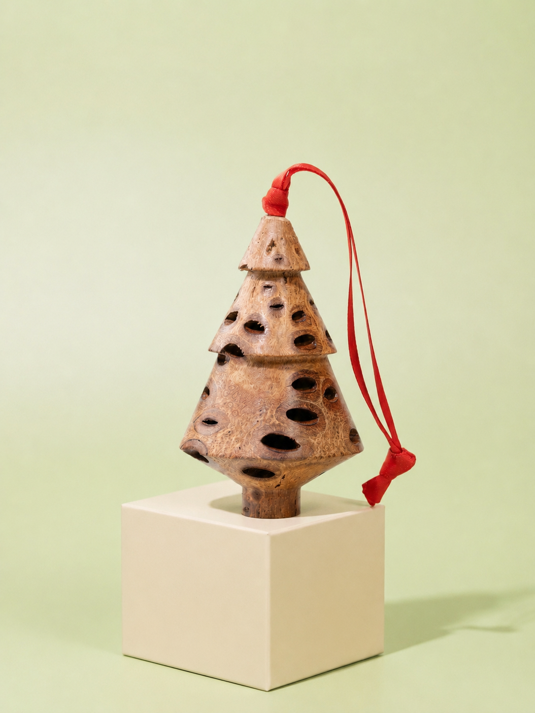 Handcrafted Banksia seed pod tiered Christmas tree decoration with red ribbon on sage green